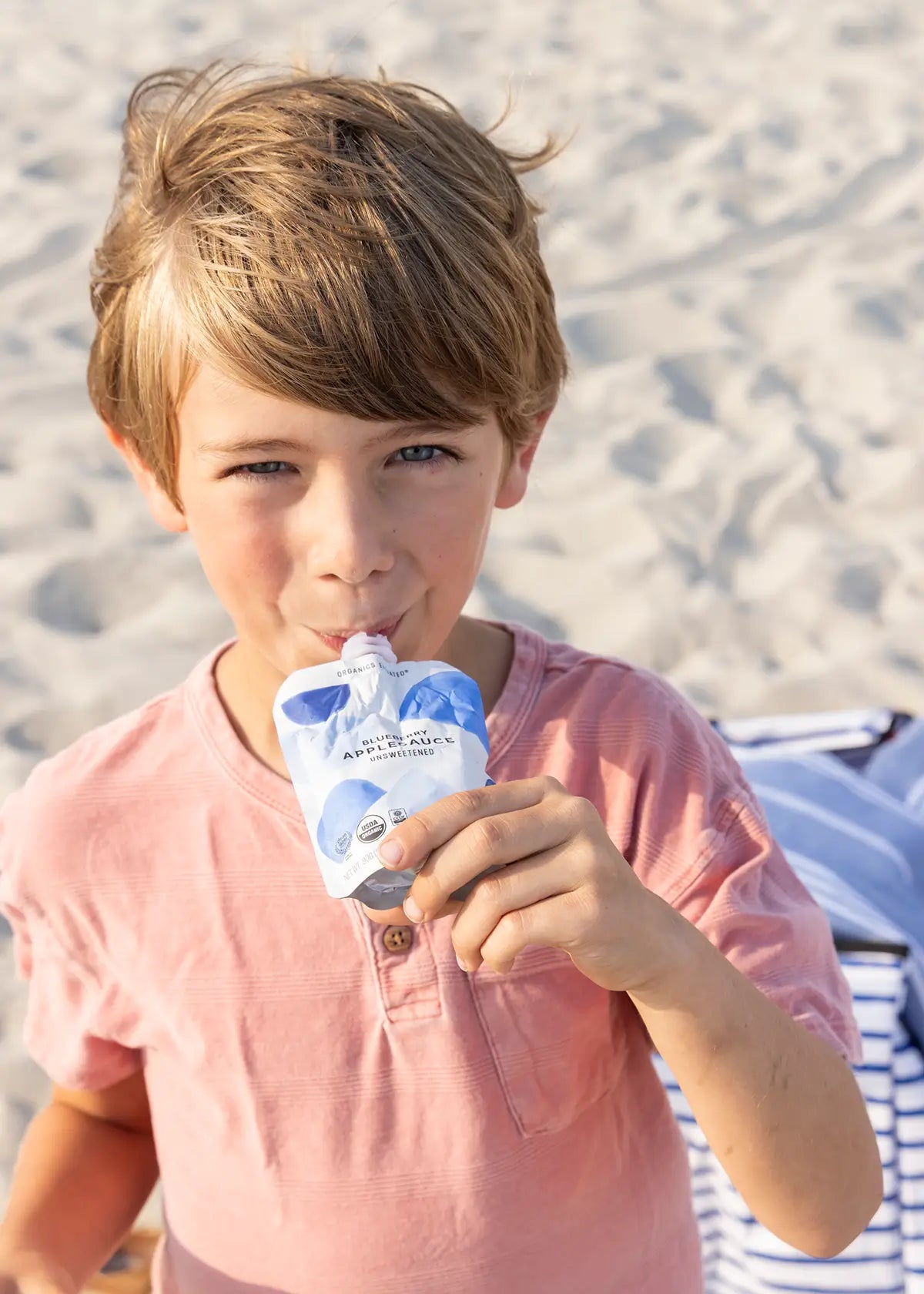 Boy sipping blueberry applesauce pouch