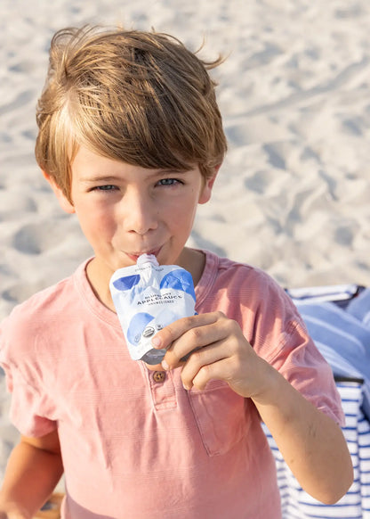 Boy sipping blueberry applesauce pouch